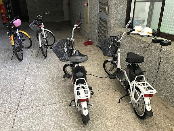 Charging station for campus electrical bikes, equipped with helmets. (Taitung University)